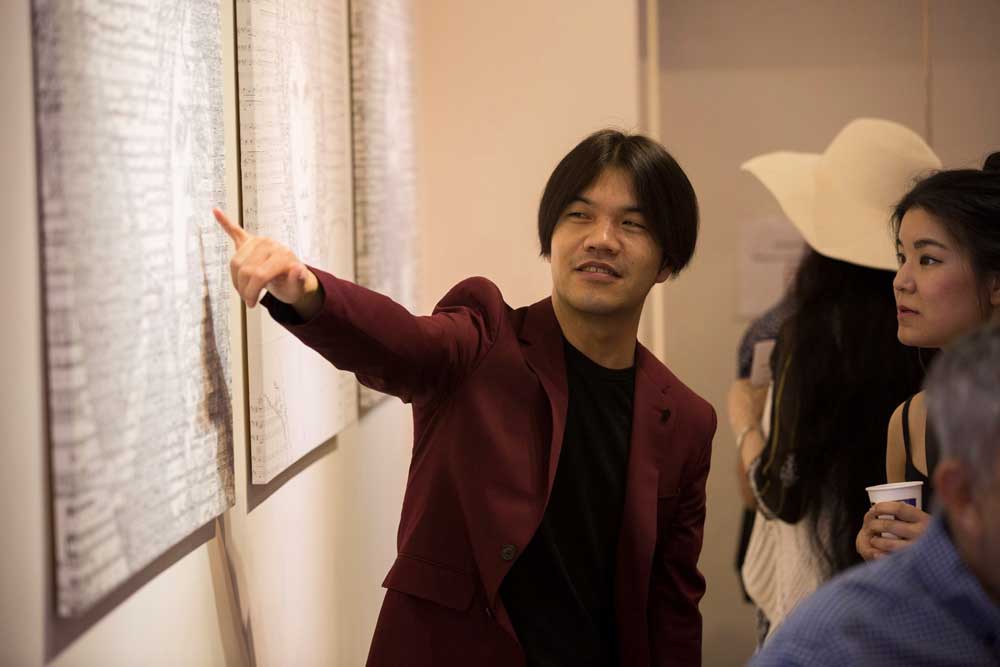 Artist Hayato Takano explaining to guest how he creates his unique masterpiece.